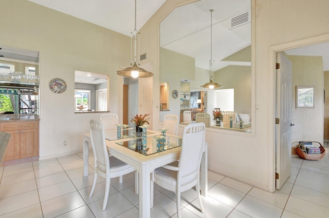 dining area with vaulted ceiling and light tile patterned floors