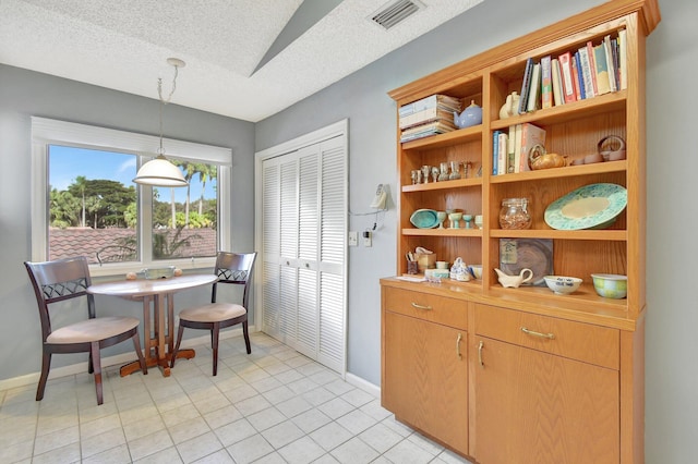 tiled dining room with a textured ceiling