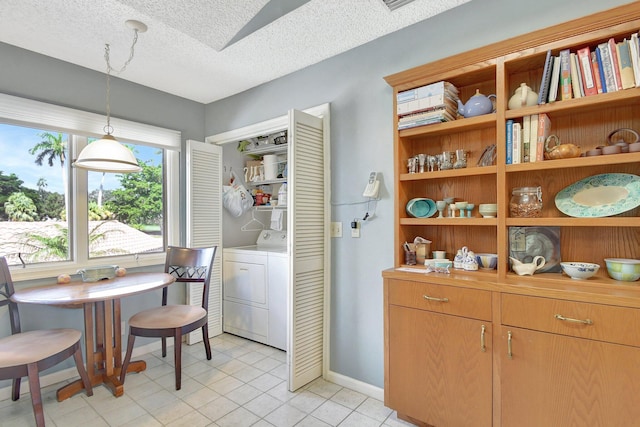 dining area with washing machine and dryer, a textured ceiling, and light tile patterned floors