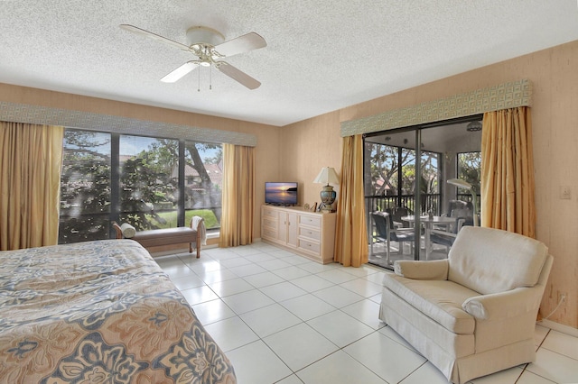 bedroom featuring ceiling fan, light tile patterned flooring, access to exterior, and a textured ceiling