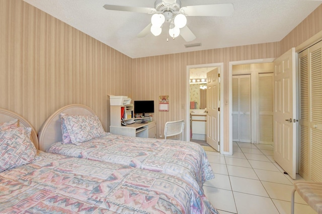 tiled bedroom featuring a textured ceiling and ceiling fan