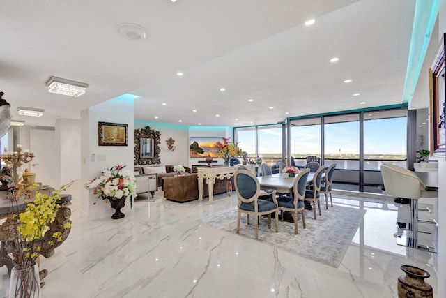 dining space featuring a water view and floor to ceiling windows