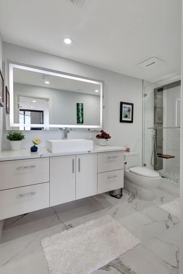 bathroom with tiled shower, vanity, and toilet