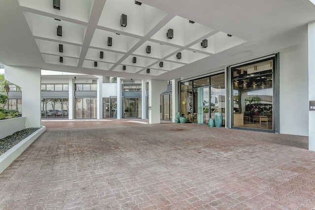 unfurnished living room featuring coffered ceiling, beam ceiling, and plenty of natural light