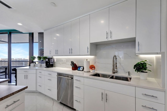 kitchen featuring white cabinetry, sink, dishwasher, and tasteful backsplash