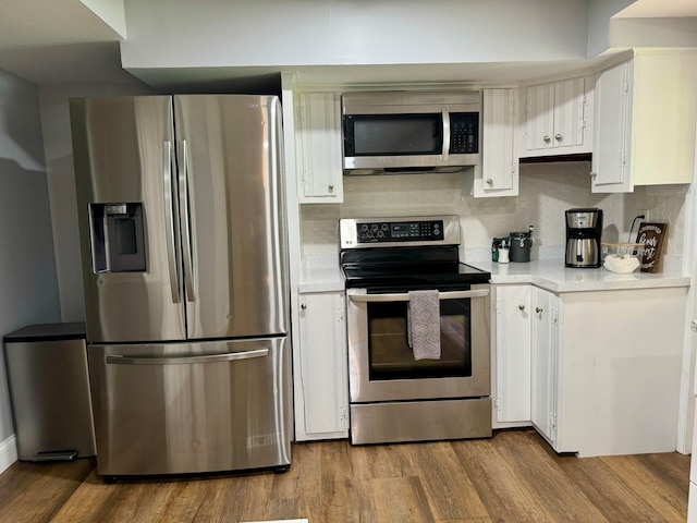 kitchen featuring appliances with stainless steel finishes, light hardwood / wood-style floors, and white cabinets