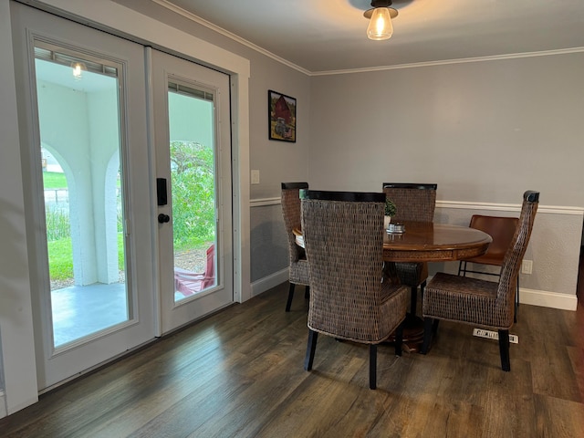 dining room featuring dark wood-type flooring and crown molding