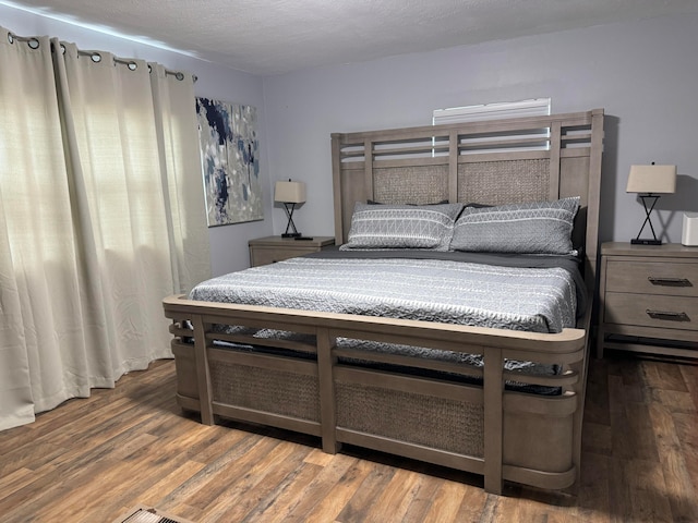 bedroom featuring dark wood-type flooring and a textured ceiling