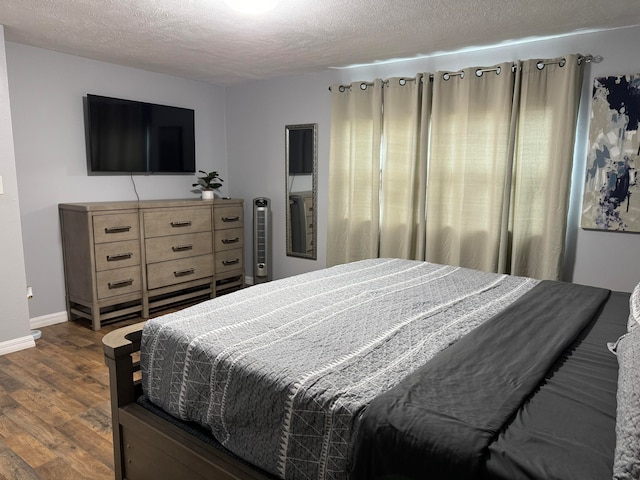 bedroom featuring dark wood-type flooring and a textured ceiling