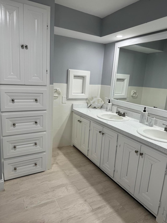 bathroom featuring vanity and tile walls