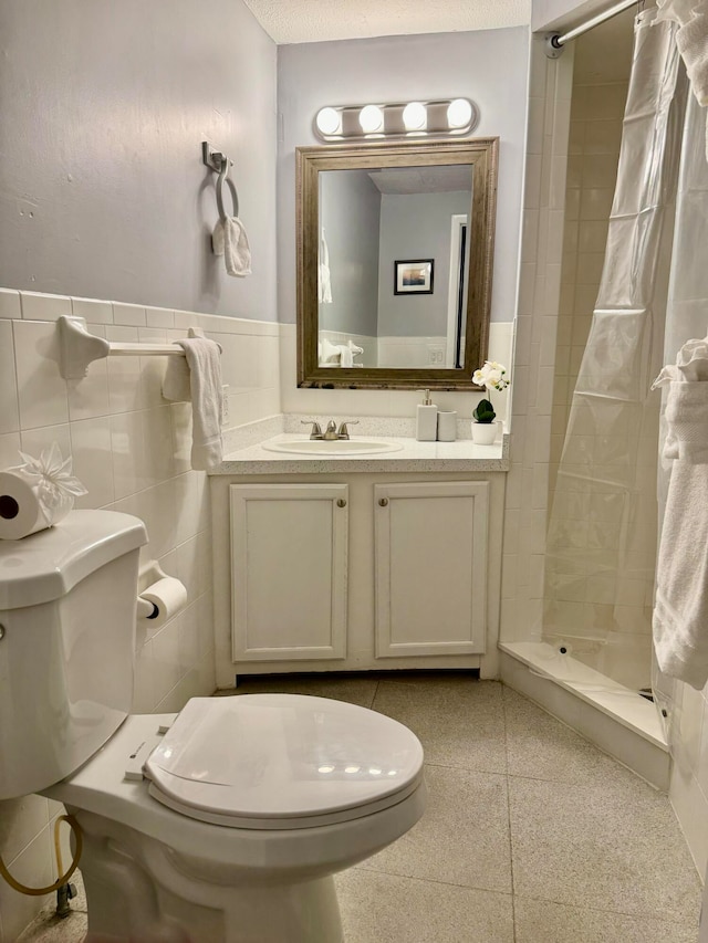 bathroom featuring a shower with shower curtain, vanity, toilet, and tile walls