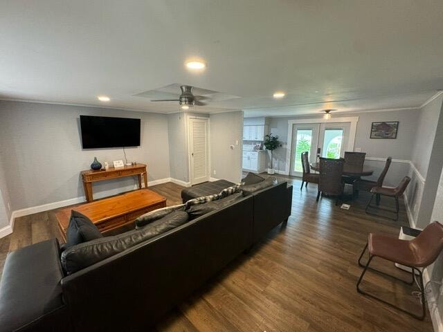 living room featuring french doors, dark wood-type flooring, ceiling fan, and crown molding