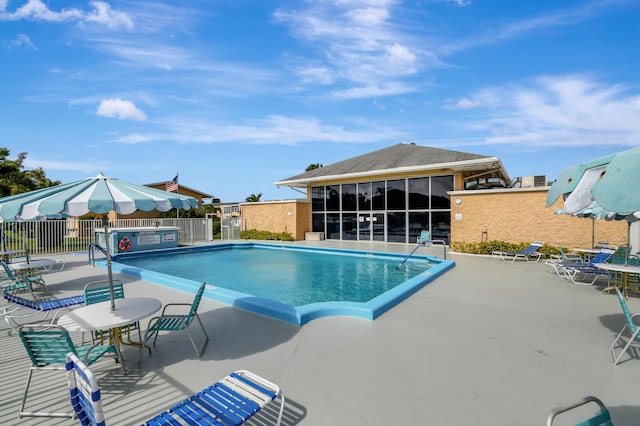 view of swimming pool featuring a sunroom and a patio area