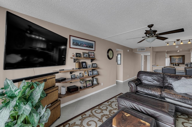 living room featuring ceiling fan, a textured ceiling, and light tile patterned floors