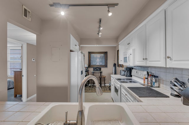 kitchen with sink, track lighting, white appliances, white cabinets, and tile counters