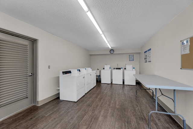 washroom featuring a textured ceiling, washing machine and dryer, and dark hardwood / wood-style floors