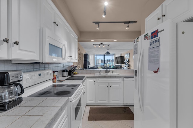 kitchen featuring decorative backsplash, sink, tile counters, white cabinets, and white appliances