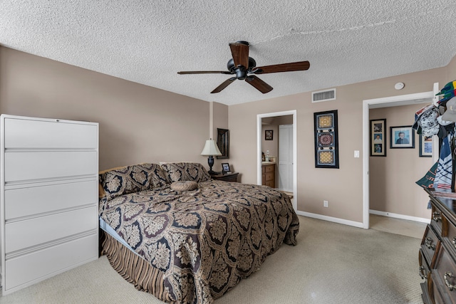 bedroom featuring a textured ceiling, ensuite bath, and ceiling fan