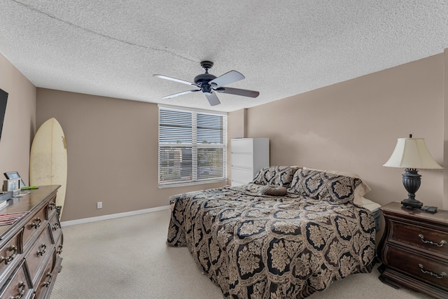 carpeted bedroom with ceiling fan and a textured ceiling