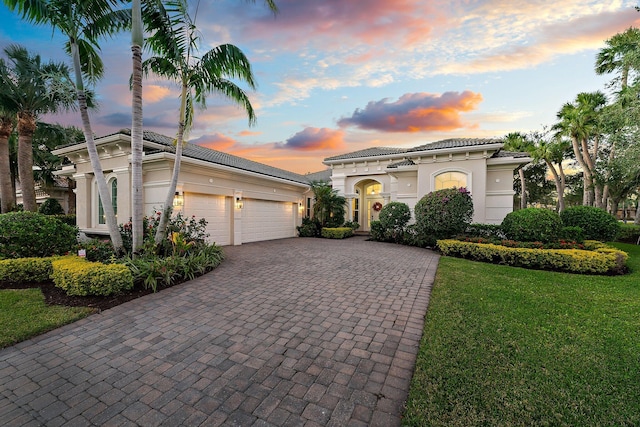 mediterranean / spanish house with a garage and a yard