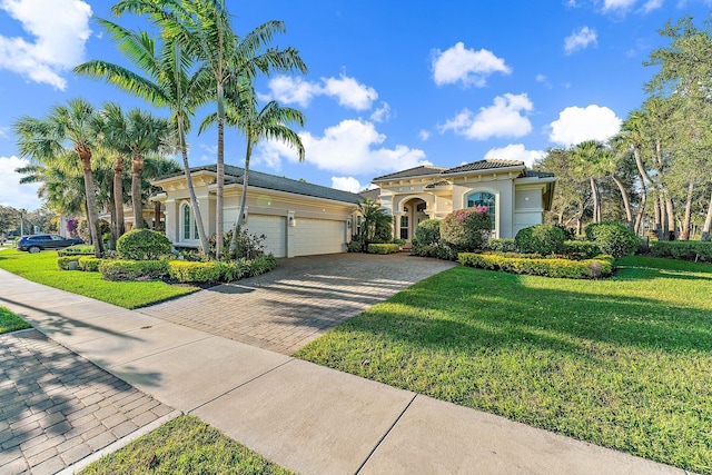 mediterranean / spanish-style house featuring a front yard and a garage