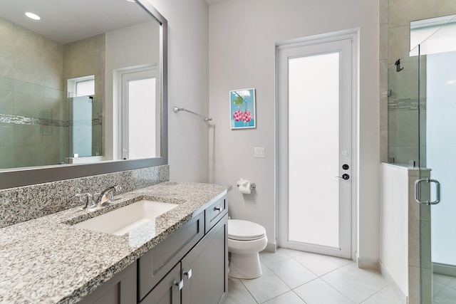 bathroom featuring walk in shower, tile patterned flooring, plenty of natural light, toilet, and vanity