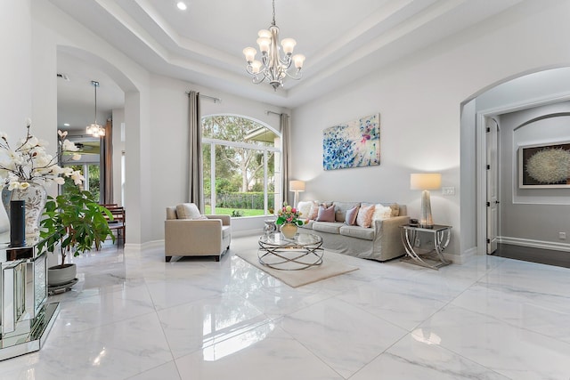 living room featuring a raised ceiling and a notable chandelier