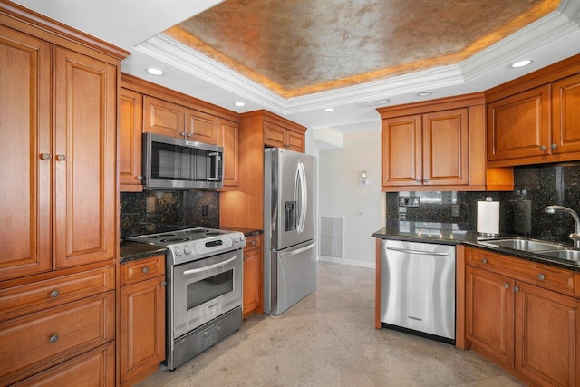 kitchen with stainless steel appliances, tasteful backsplash, sink, and a raised ceiling