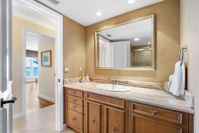 bathroom featuring walk in shower, hardwood / wood-style floors, and vanity