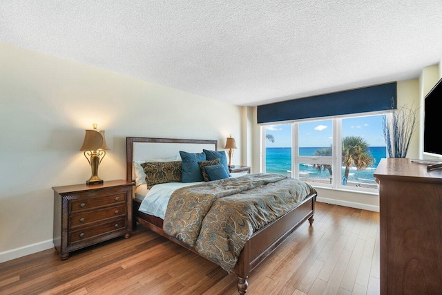 bedroom featuring a textured ceiling and hardwood / wood-style flooring