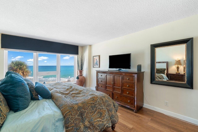 bedroom with a textured ceiling and hardwood / wood-style flooring