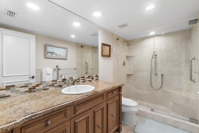 bathroom with a shower with door, backsplash, vanity, tile patterned flooring, and toilet