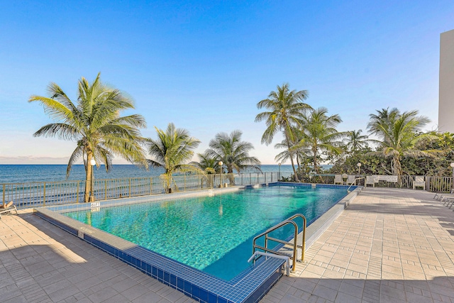 view of pool with a water view and a patio area