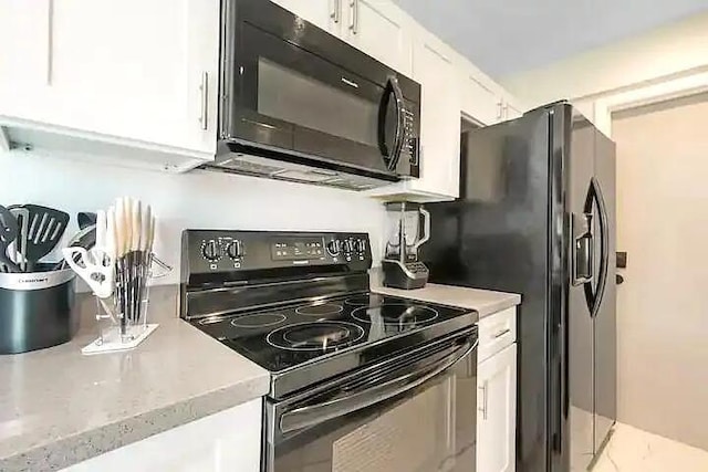 kitchen featuring white cabinets and black appliances