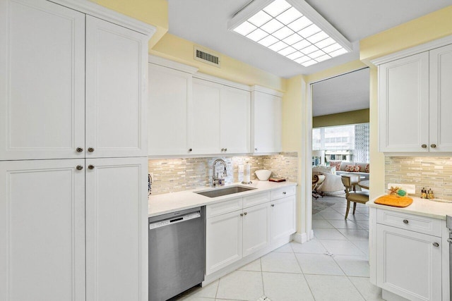 kitchen featuring stainless steel dishwasher, white cabinetry, sink, and tasteful backsplash