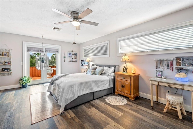 bedroom featuring access to outside, ceiling fan, a textured ceiling, and dark hardwood / wood-style floors