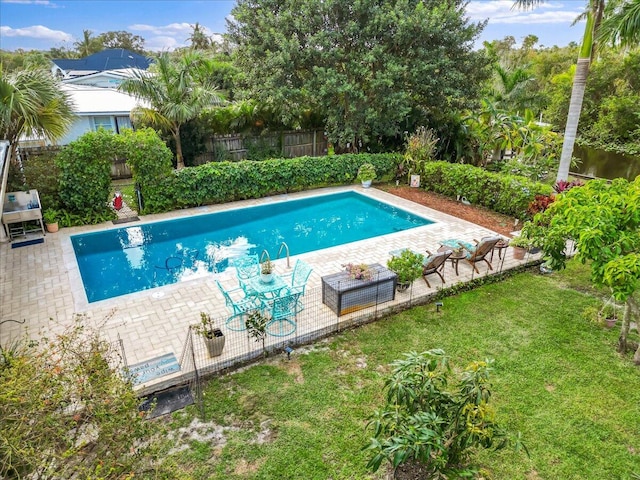 view of pool with a lawn and a patio