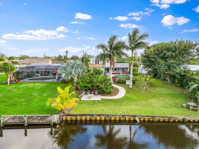 rear view of property with a lawn, a lanai, and a water view