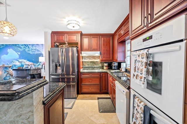 kitchen with hanging light fixtures, tasteful backsplash, dark stone countertops, light tile patterned floors, and appliances with stainless steel finishes