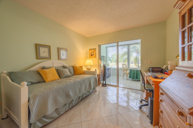 bedroom featuring access to exterior, light tile patterned floors, and a textured ceiling