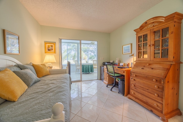 bedroom featuring access to outside, light tile patterned floors, and a textured ceiling