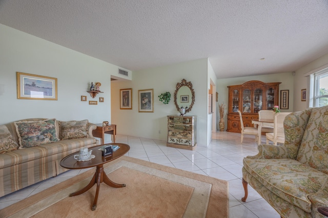 living room featuring a textured ceiling and light tile patterned flooring