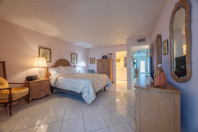 bedroom featuring connected bathroom, a textured ceiling, and light tile patterned flooring