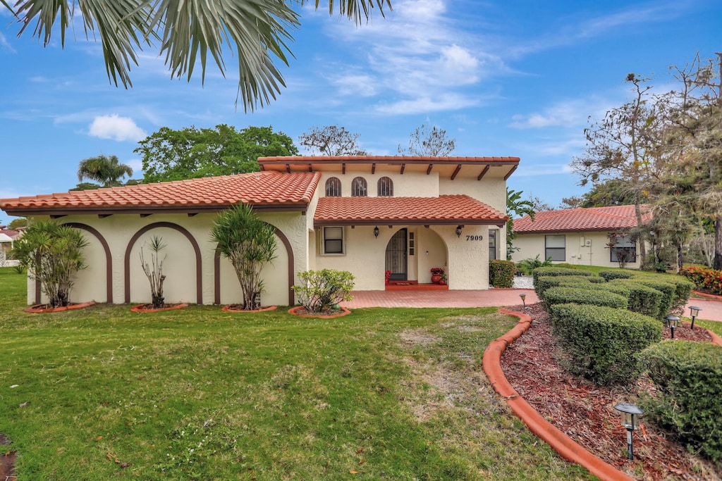 mediterranean / spanish house with a front yard