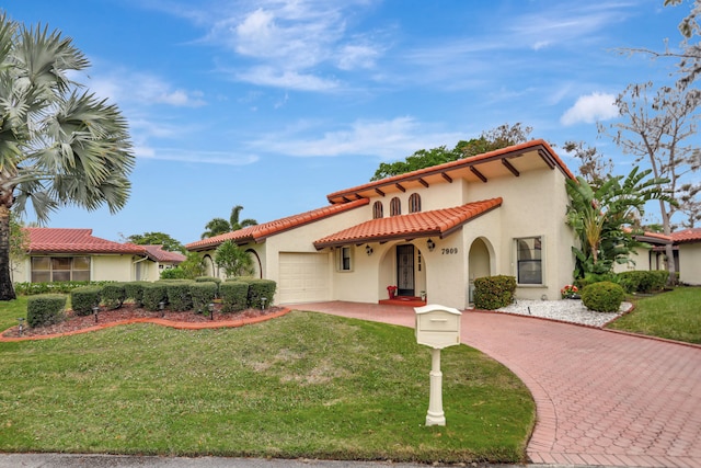 mediterranean / spanish-style home with a garage and a front yard