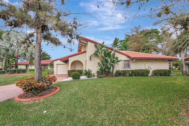 mediterranean / spanish-style home featuring a garage and a front yard