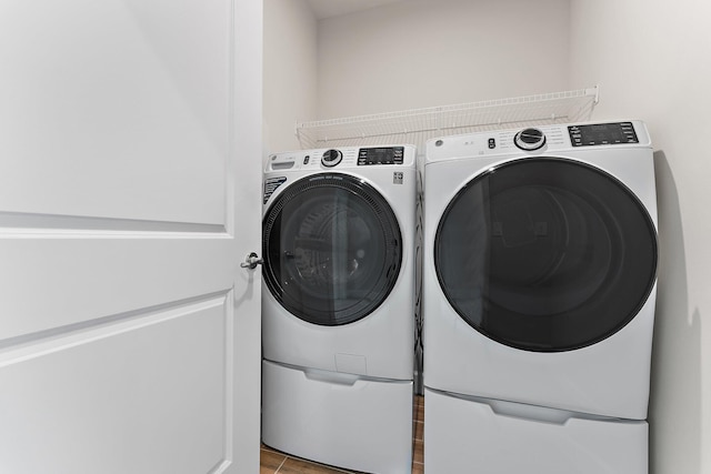 laundry area featuring separate washer and dryer and light tile patterned floors