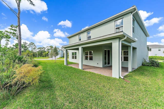 rear view of house with a yard and a patio