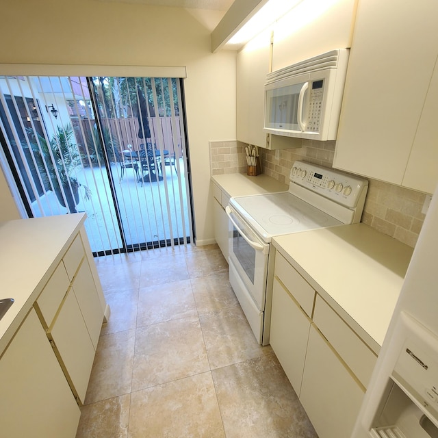 kitchen featuring white appliances, decorative backsplash, light countertops, white cabinetry, and light tile patterned flooring