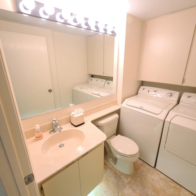 bathroom with vanity, washing machine and dryer, tile patterned floors, and toilet